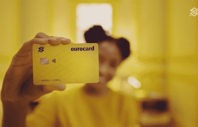 uma mulher segurando o cartao de credito BB Ourocard Internacional 640x412 1